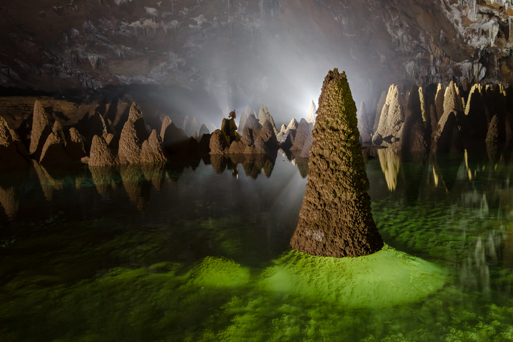 A caver stands amongst unique cave formations in Hang Va, Phong Nha Ke Bang, Vietnam